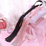 a black and pink bdsm whip in bedroom