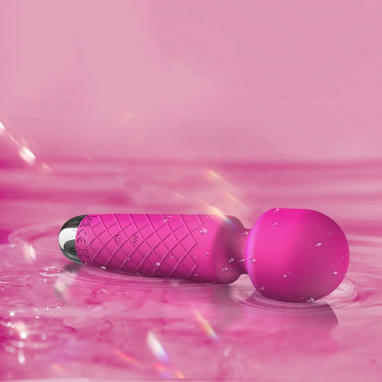 a beautiful rose color wand vibrator lay on water